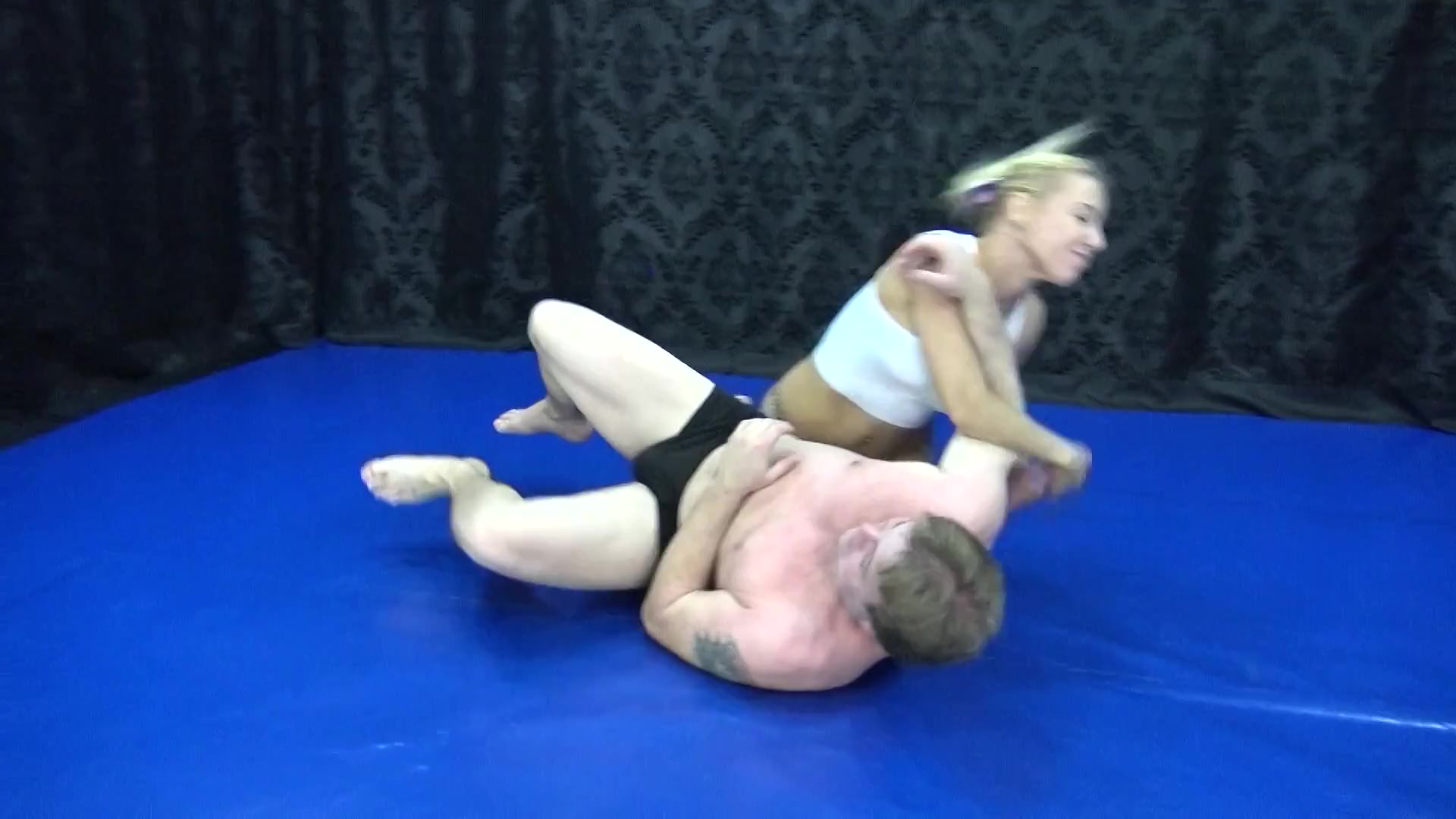 Smothering femdoms defeating male in wrestling 3some on the mat